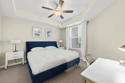 a bedroom with a blue bed and a ceiling fan at Designer Apt with Jacuzzi, Sky Lounge, Gym Access in Sparks
