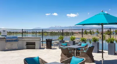 a patio with a table and chairs and an umbrella at Designer Apt with Jacuzzi, Sky Lounge, Gym Access in Sparks