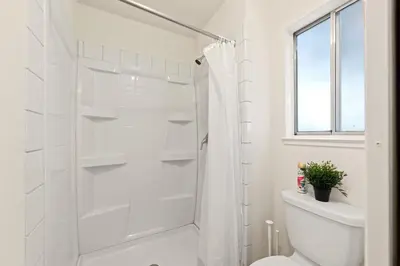 a white bathroom with a shower and a toilet at Delightful 4BR Home Nr Downtown Reno w Fireplace in Reno
