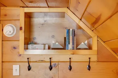 a wooden wall with a shelf with books at 3 Mi to Big Trees State Park Cabin with Scenic Deck in Arnold