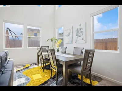 a dining room with a table and chairs and windows at Madera lovely home in Madera