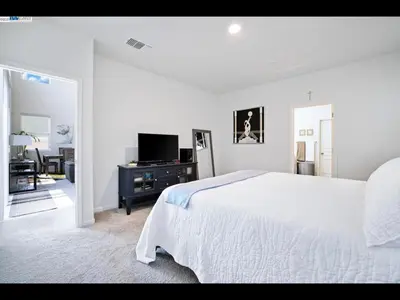 a white bedroom with a bed and a television at Madera lovely home in Madera