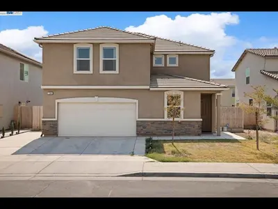 a large brown house with a white garage at Madera lovely home in Madera
