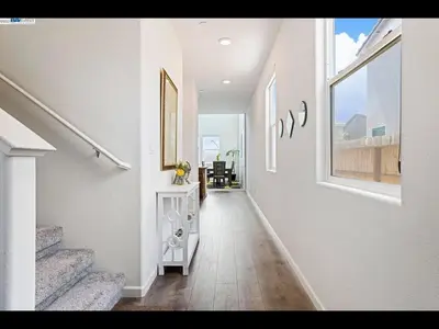 a hallway with white walls and a staircase with a table at Madera lovely home in Madera