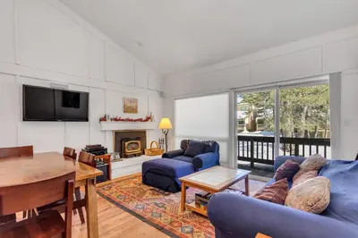 a living room with a blue couch and a table at Stylish, Remodeled Condo - Creekside #14 in Bear Valley