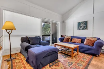 a living room with two blue couches and a table at Stylish, Remodeled Condo - Creekside #14 in Bear Valley