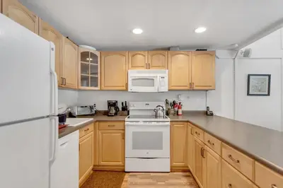 a kitchen with white appliances and wooden cabinets at Stylish, Remodeled Condo - Creekside #14 in Bear Valley
