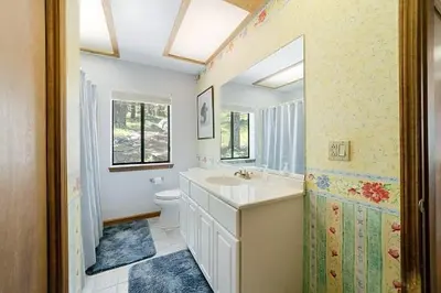 a bathroom with a sink and a toilet and a mirror at Spacious Cabin Sleeps up to 12 - Sky High #86 in Bear Valley