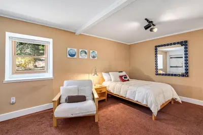 a bedroom with a bed and a chair and a window at Mountain Getaway with Granny Unit, Dogs Ok #47 in Bear Valley