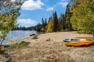 two kayaks on a sandy beach next to a lake at Mountain Getaway with Granny Unit, Dogs Ok #47 in Bear Valley