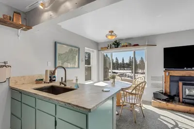 a kitchen with a sink and a counter with a tv at Great Location Corner Condo - Tamarack #10 Pets Ok in Bear Valley