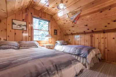 a bedroom with two beds in a log cabin at Woodsy Wonder in Tahoe City
