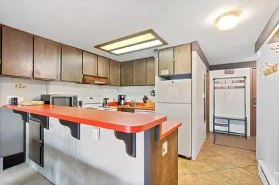 a kitchen with a red counter top and a refrigerator at Relaxing, Well Furnished Condo! - Creekside #29 in Bear Valley