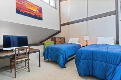 a room with two beds and a desk and a computer at Relaxing, Well Furnished Condo! - Creekside #29 in Bear Valley