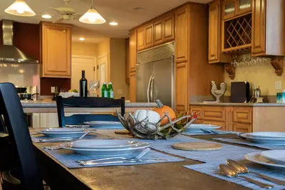 a kitchen with a table with plates and dishes on it at Epic View A Luxury House on a Hill River 10 min in Kernville