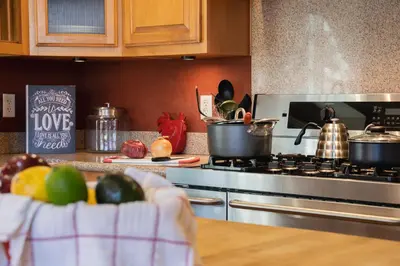 a kitchen with a stove with pots and pans on it at Epic View A Luxury House on a Hill River 10 min in Kernville