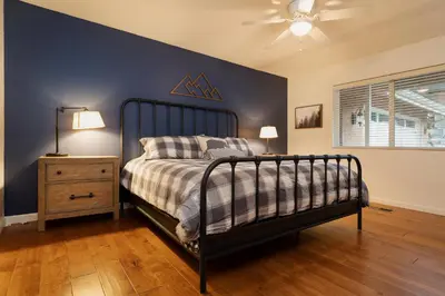 a bedroom with a bed and a blue wall at Epic View A Luxury House on a Hill River 10 min in Kernville