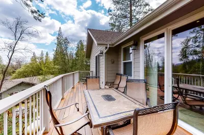 a deck with a table and chairs on a porch at Murray Lake Retreat in Bass Lake