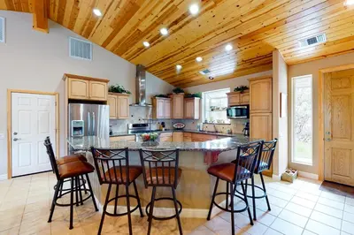 a kitchen with a large island with bar stools at Murray Lake Retreat in Bass Lake