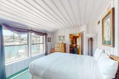 a bedroom with a large bed and a large window at Paha Lakefront in Bass Lake