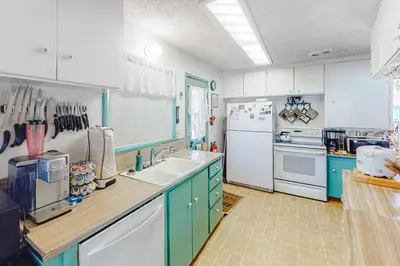 a kitchen with blue cabinets and a white refrigerator at Paha Lakefront in Bass Lake