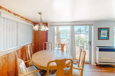 a dining room with a wooden table and chairs at Paha Lakefront in Bass Lake