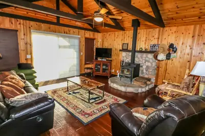 a living room with leather furniture and a fireplace at Calandri Lakeview House in Bass Lake