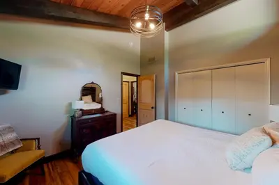 a bedroom with a large white bed and a mirror at Twets Lakefront in Bass Lake
