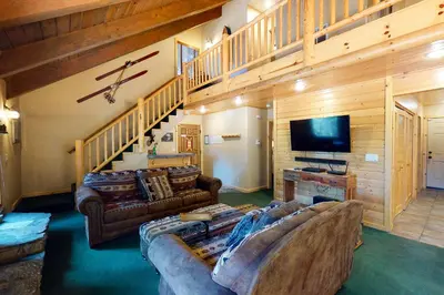 a living room with a couch and a tv at Yosemite Silvertip Lodge in Fish Camp