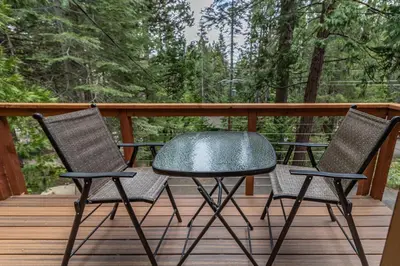 a table and two chairs on a deck at Yosemite Silvertip Lodge in Fish Camp