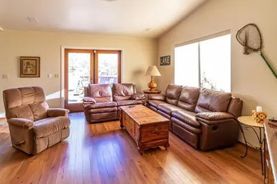 a living room with leather couches and a table at Alder Lake View Lodge in Bass Lake