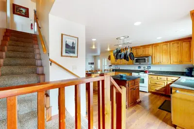 a large kitchen with wooden cabinets and a staircase at Alder Lake View Lodge in Bass Lake