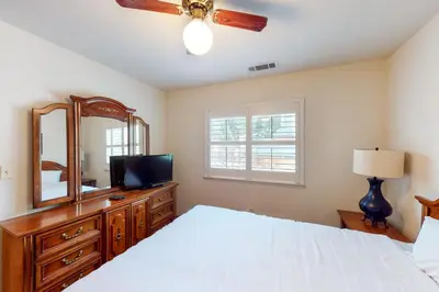 a bedroom with a bed and a dresser with a mirror at Alder Lake View Lodge in Bass Lake