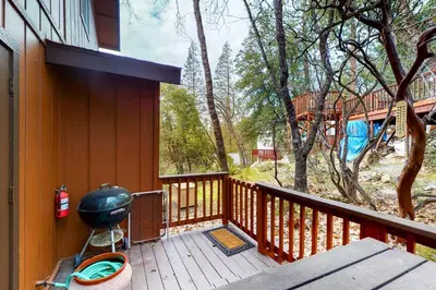 a balcony with a grill on the side of a house at Alder Lake View Lodge in Bass Lake