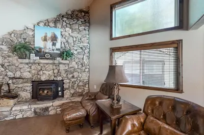 a living room with a stone wall at Brickers Lakefront in Bass Lake