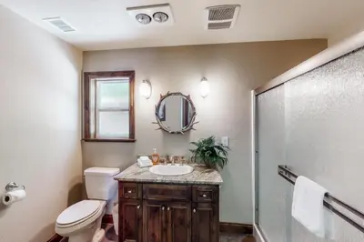 a bathroom with a toilet and a sink and a shower at Brickers Lakefront in Bass Lake