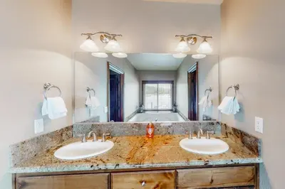 a bathroom with two sinks and a large mirror at Brickers Lakefront in Bass Lake