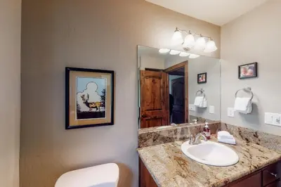 a bathroom with a sink and a mirror at Brickers Lakefront in Bass Lake