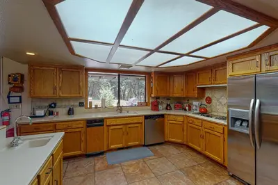 a kitchen with wooden cabinets and stainless steel appliances at Yosemite Nutter Ranch in Mariposa