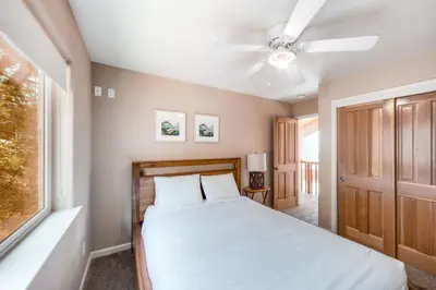 a bedroom with a bed and a ceiling fan at Robinson Shoreline House in Bass Lake
