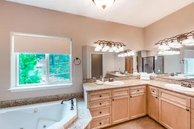 a bathroom with two sinks and a tub and a window at Robinson Shoreline House in Bass Lake