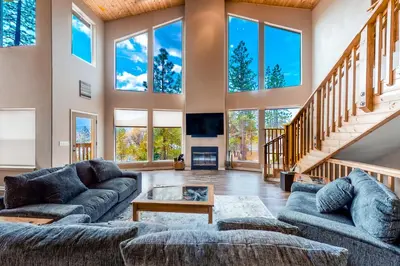 a large living room with large windows and couches at Robinson Shoreline House in Bass Lake