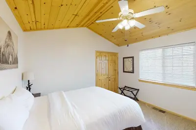 a bedroom with a white bed and a ceiling fan at Brier Escape in Bass Lake