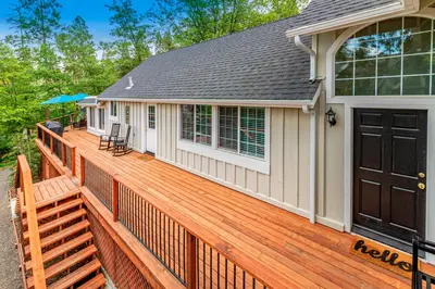 a large wooden deck with two chairs on it at Brier Escape in Bass Lake