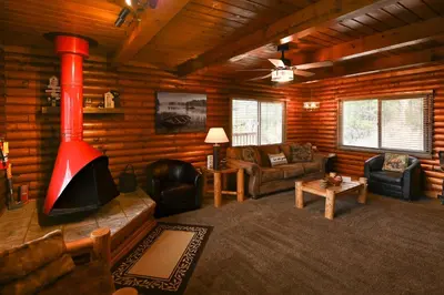 a living room with a fireplace in a log cabin at Harris Lakeview Cabin in Bass Lake