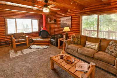 a living room with a couch and a table at Harris Lakeview Cabin in Bass Lake