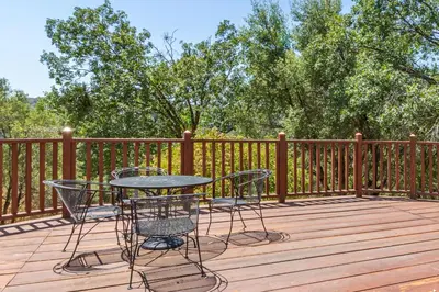 a patio with a table and chairs on a wooden deck at Putney Place in North Fork