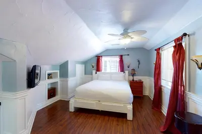 a bedroom with a white bed and a ceiling fan at Humphreys Lakefront in Bass Lake