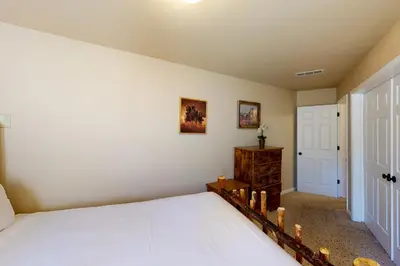 a bedroom with a white bed and a door at Humphreys Lakefront in Bass Lake