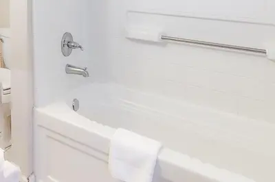 a white bathroom with a tub and a sink at Alford Family Lodge in Bass Lake